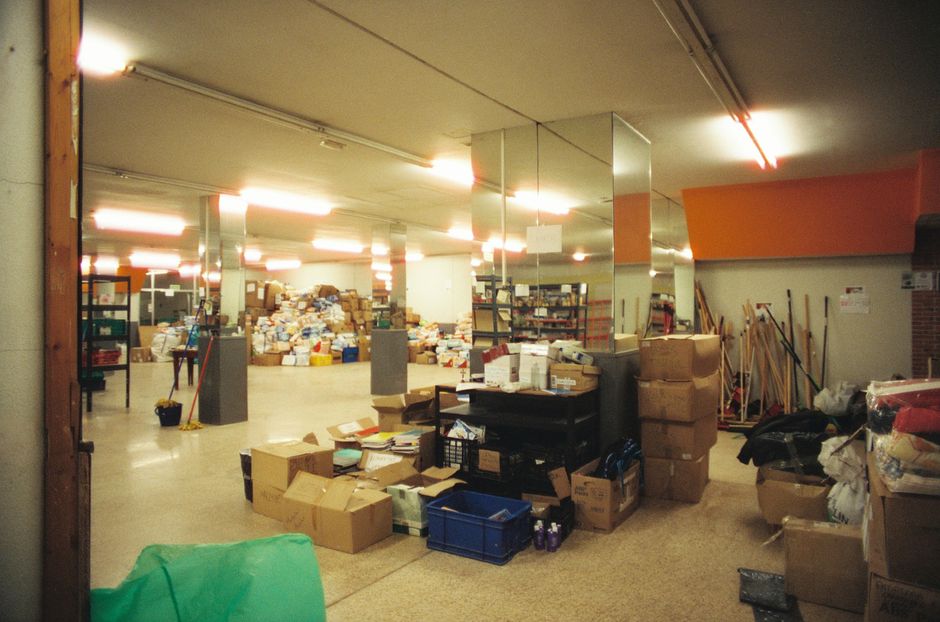 Stacked boxes and stored items in a basement storage room awaiting clearance
