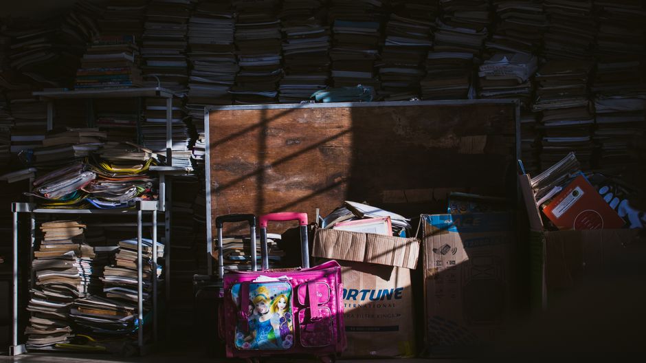Shelves and floor space filled with stacked papers, files and accumulated belongings