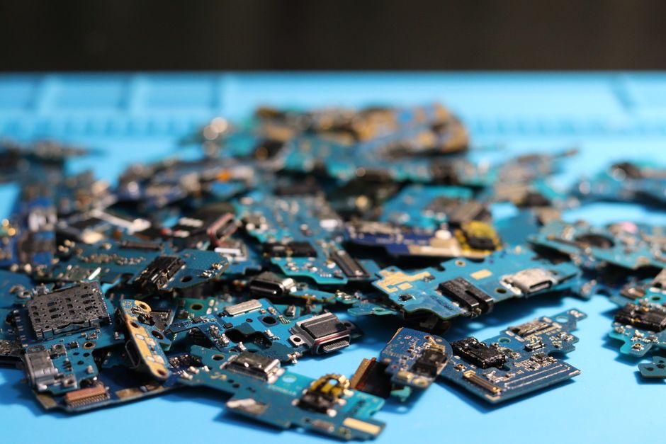 A pile of dismantled circuit boards and small electronic components removed from old equipment during recycling