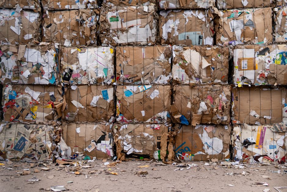 Baled cardboard and paper recycling material stacked at a waste recycling facility