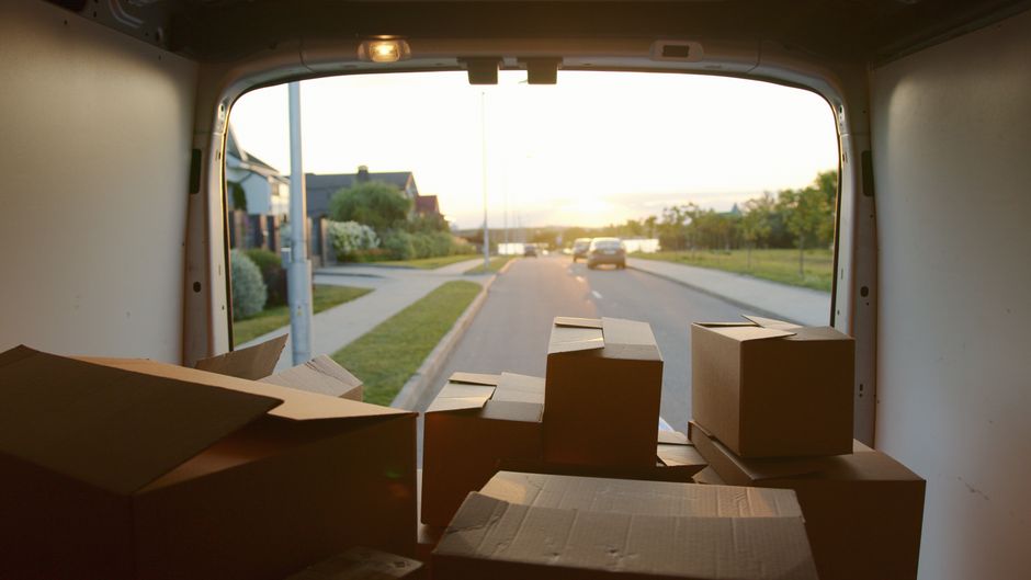 Open van doors showing stacked cardboard boxes ready for a house move