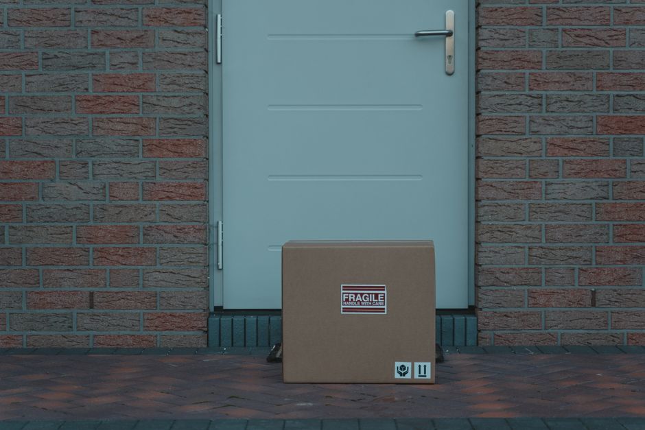 Cardboard parcel with a fragile label left outside a front door