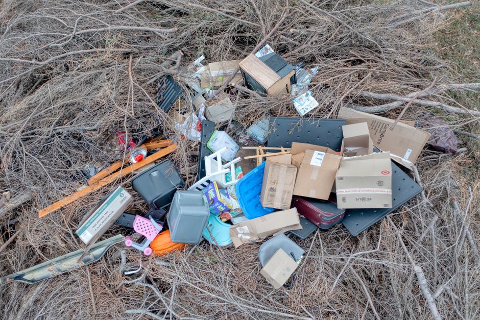 Household rubbish and boxes dumped among dry undergrowth at the roadside