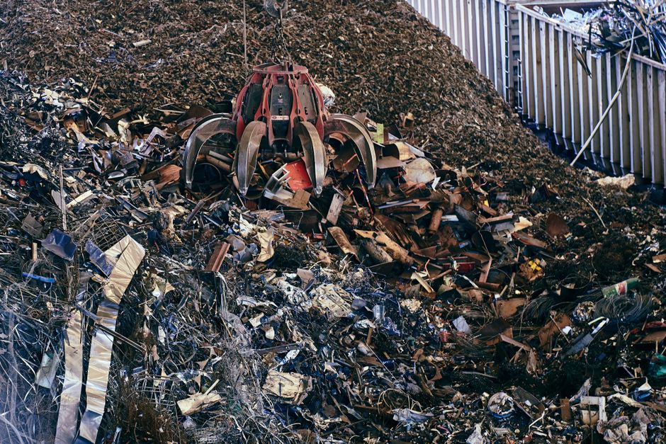 Mechanical grapple sorting scrap and waste material at a recycling facility