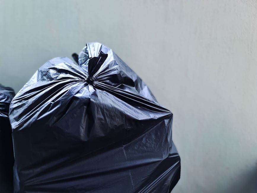 Tied black bin bag ready for rubbish removal and waste collection