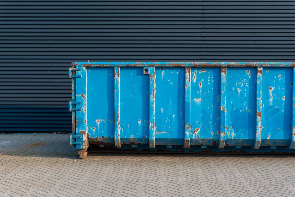 Large open-top metal skip used for construction and household waste removal