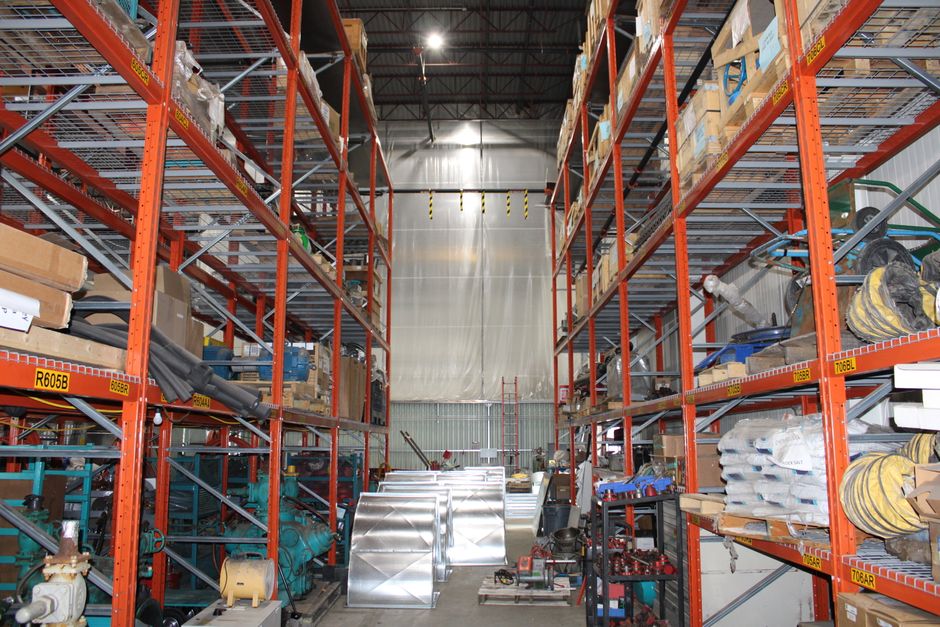 Tall industrial pallet racking inside a warehouse, loaded with boxed stock and bulky items ready for clearance